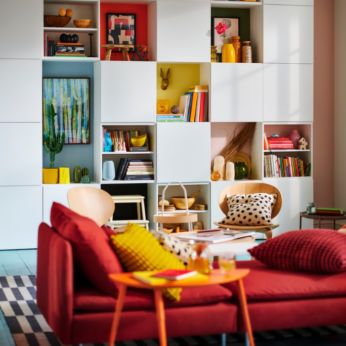 Modern living room with decorative shelving and red sofa.