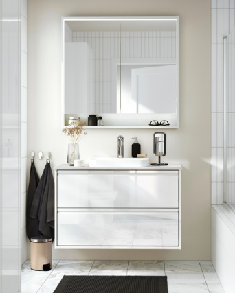 Wall-mounted white bathroom vanity with sink, large mirror, and accessories.