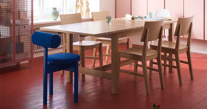 Modern dining room with wooden table and colorful decor.